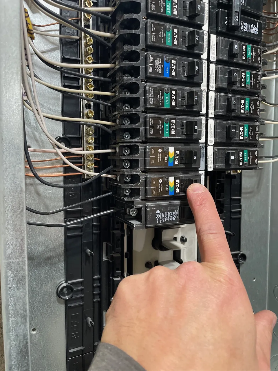 Electrician pointing to a breaker in a newly installed panel